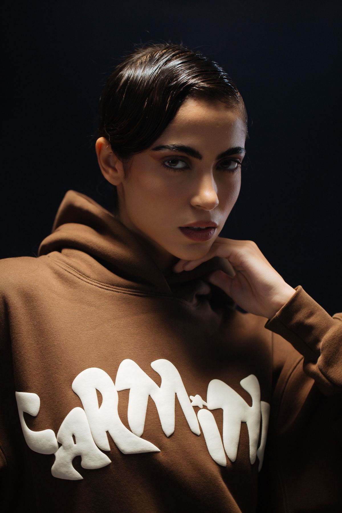 Close portrait in a brown Carmine hoodie