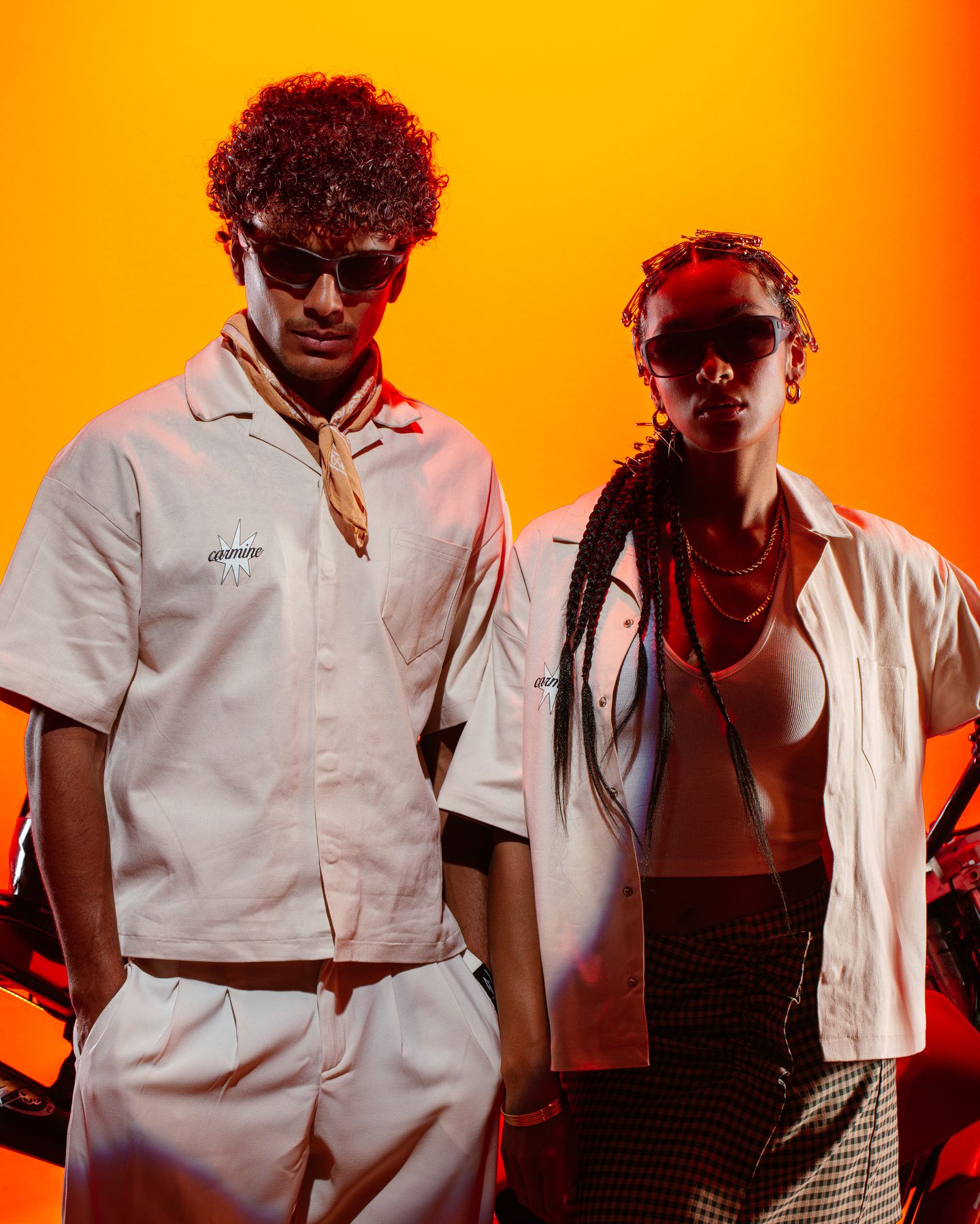 Two models in white shirts against an amber backdrop